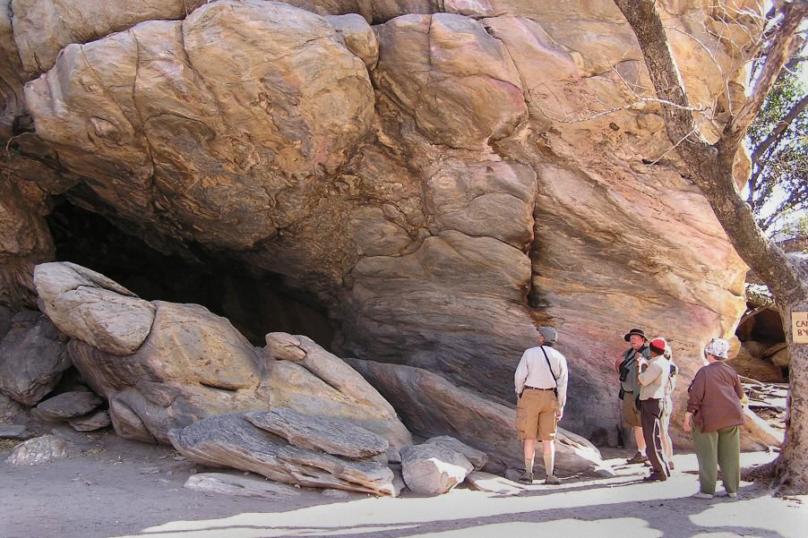 people standing outside a cave 