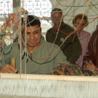 man weaving carpets