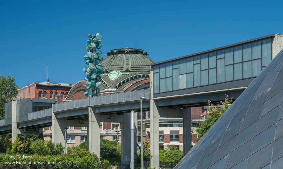 Photo looking up at the Chihuly Bridge of Glass in Tacoma, Washington, showing the Seaform Pavilon, Crystal Towers, and Venetian Wall with the US District Courthouse in the background &copy; Cindy Carlsson at ExplorationVacation.net