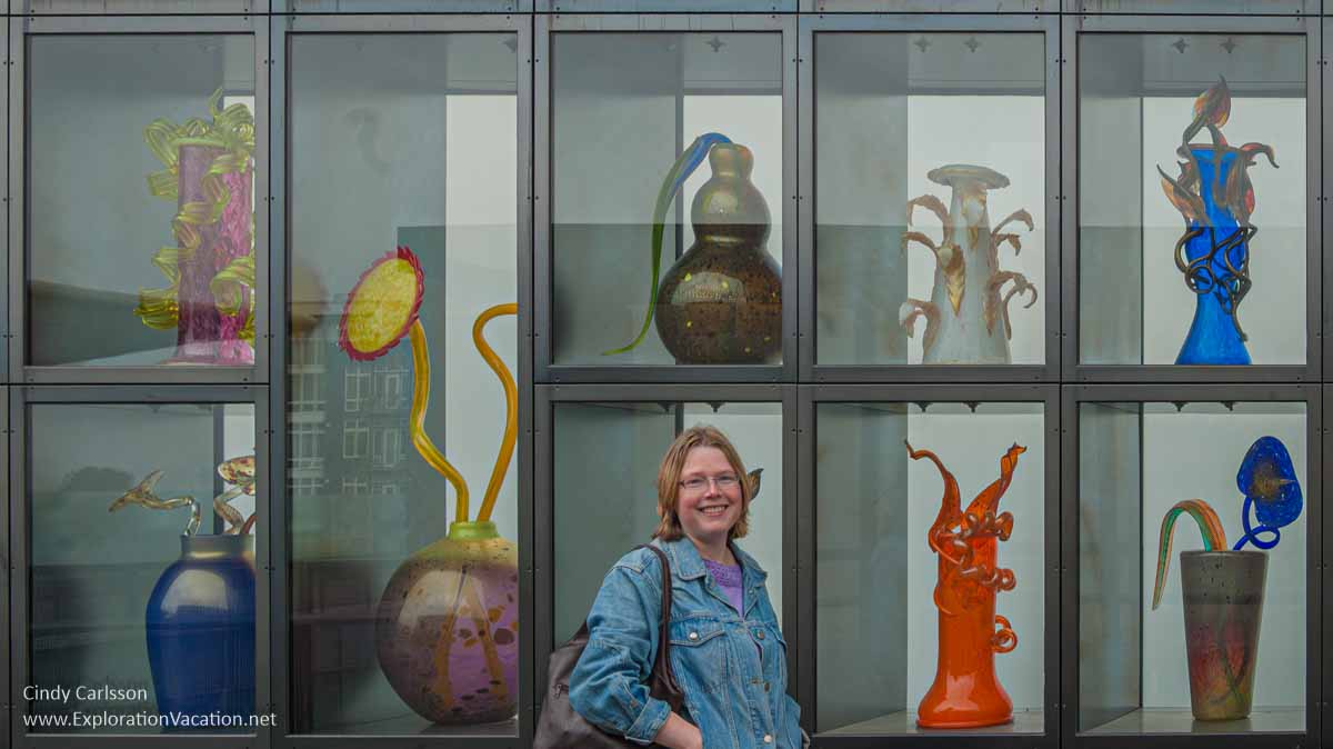 Photo of a woman standing by the Venetian Wall on the Chihuly Bridge of Glass in Tacoma, Washington&copy; Cindy Carlsson at ExplorationVacation.net