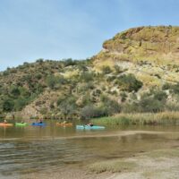 kayaks in the water below the bluff