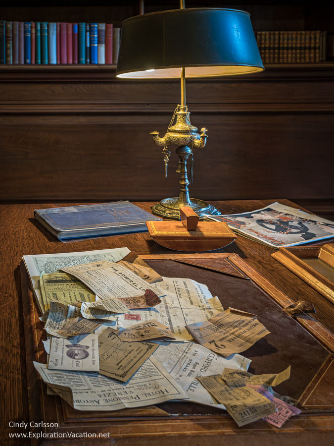 Travel receipts and tickets under a lamp on a desk in the library at Filoli House.