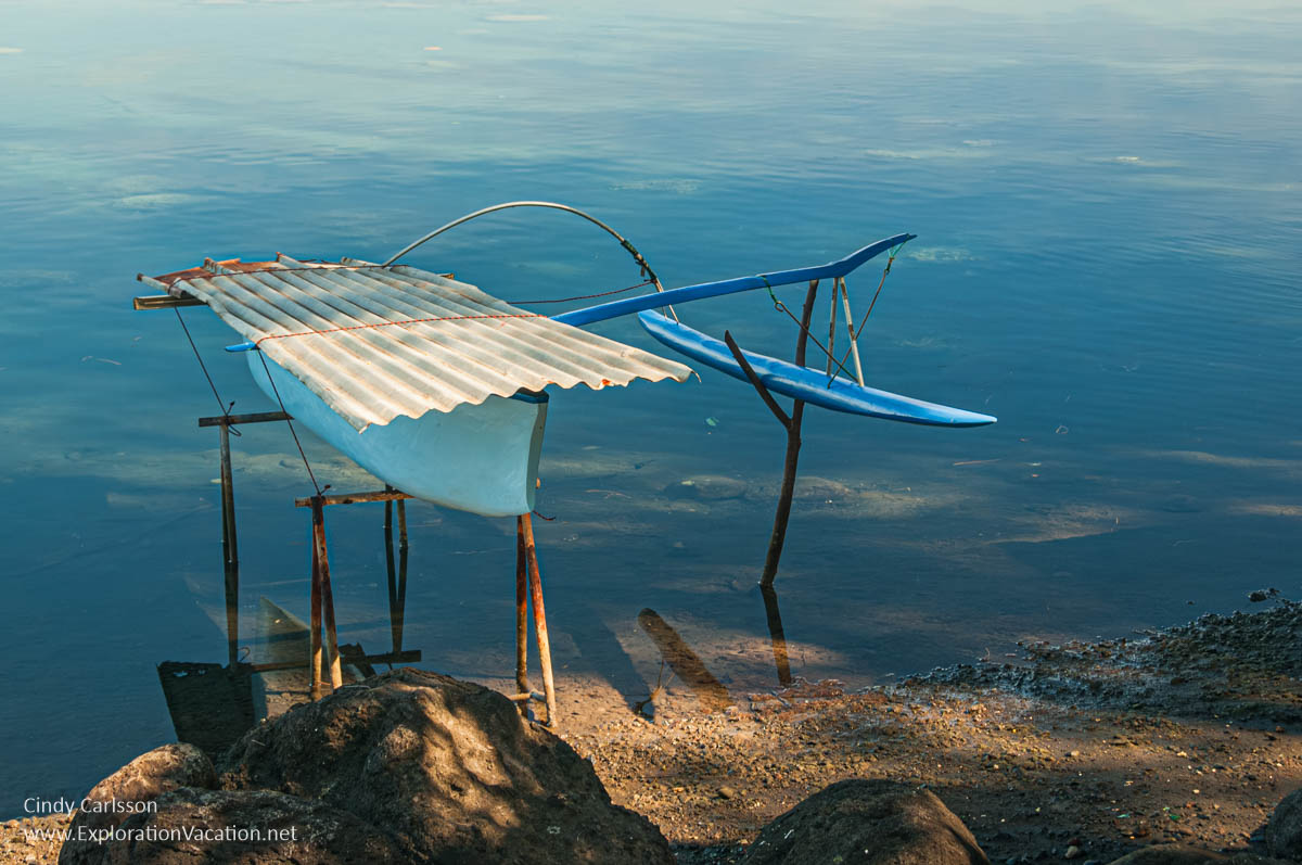 photo of a small blue boat with an outrigger and a sheet metal cover at Venus Point on Tahiti in French Polynesia &copy; Cindy Carlsson at ExplorationVacation.net