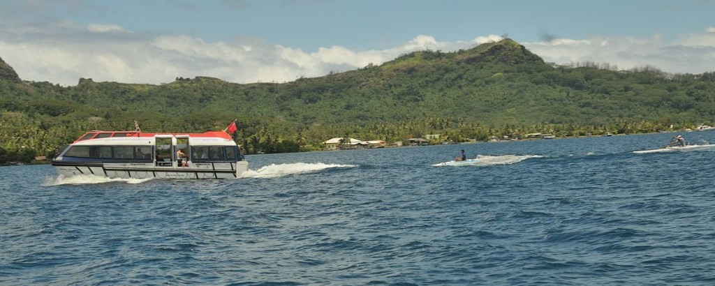 photo of men riding the wake behind a cruise ship tender on Bora Bora in French Polynesia © Cindy Carlsson at ExplorationVacation.net