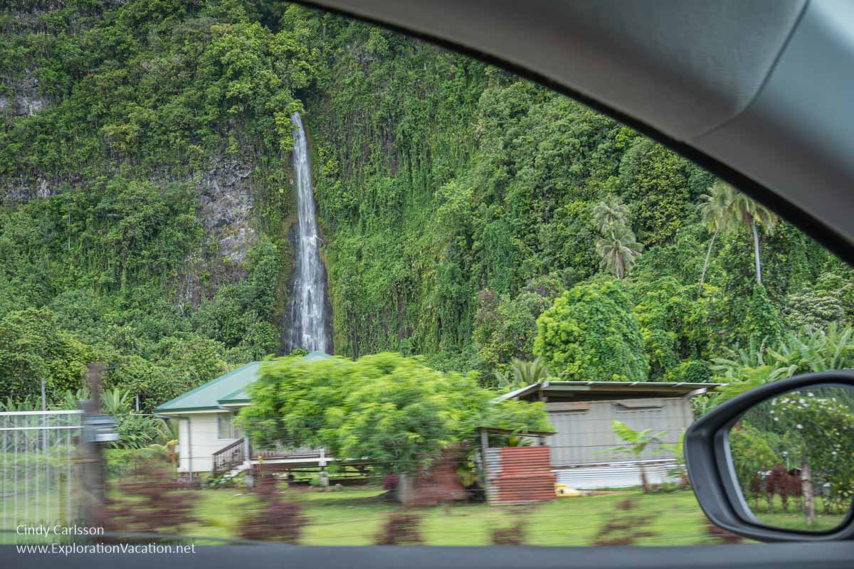 photo of a waterfall behind a village on the east side of Tahiti, French Polynesia &copy; Cindy Carlsson at ExplorationVacation