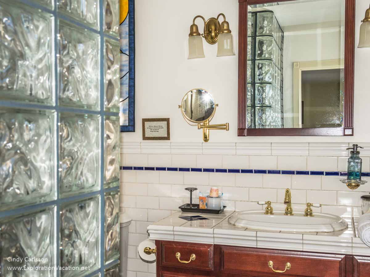 glass block wall, cabinet with a sink and mirror