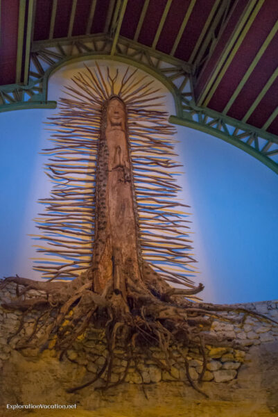 Photo of a tree carved to represent Our Lady of Guadalupe over the altar area at the Chapel of Guadalupe at Xcaret park in Playa del Carmen, Mexico © Cindy Carlsson at ExplorationVacation.net