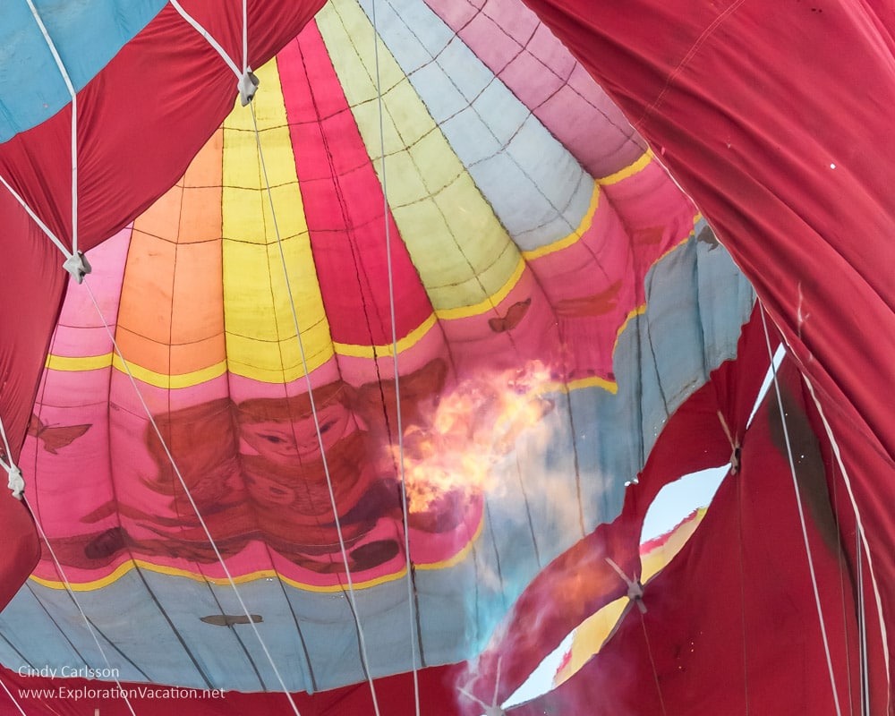 flame from burner inside balloon, with girl painted on it visible on the other side
