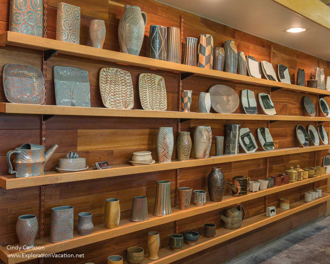 A wall lined with shelves of pottery by Carolina Niebres and Ernest Miller at Jeff Oestreich Pottery in 2024.