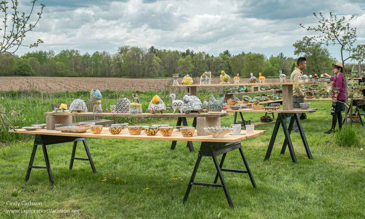 Tables near a field filled with pottery by Peter Jadoonath and Lisa Orr in 2024.