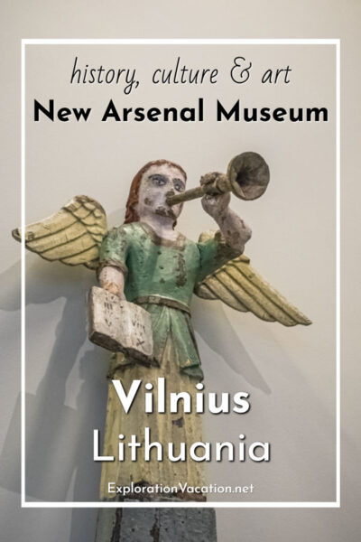 folk carving of an angel with a trumpet with text "New Arsenal Museum Vilnius Lithuania"