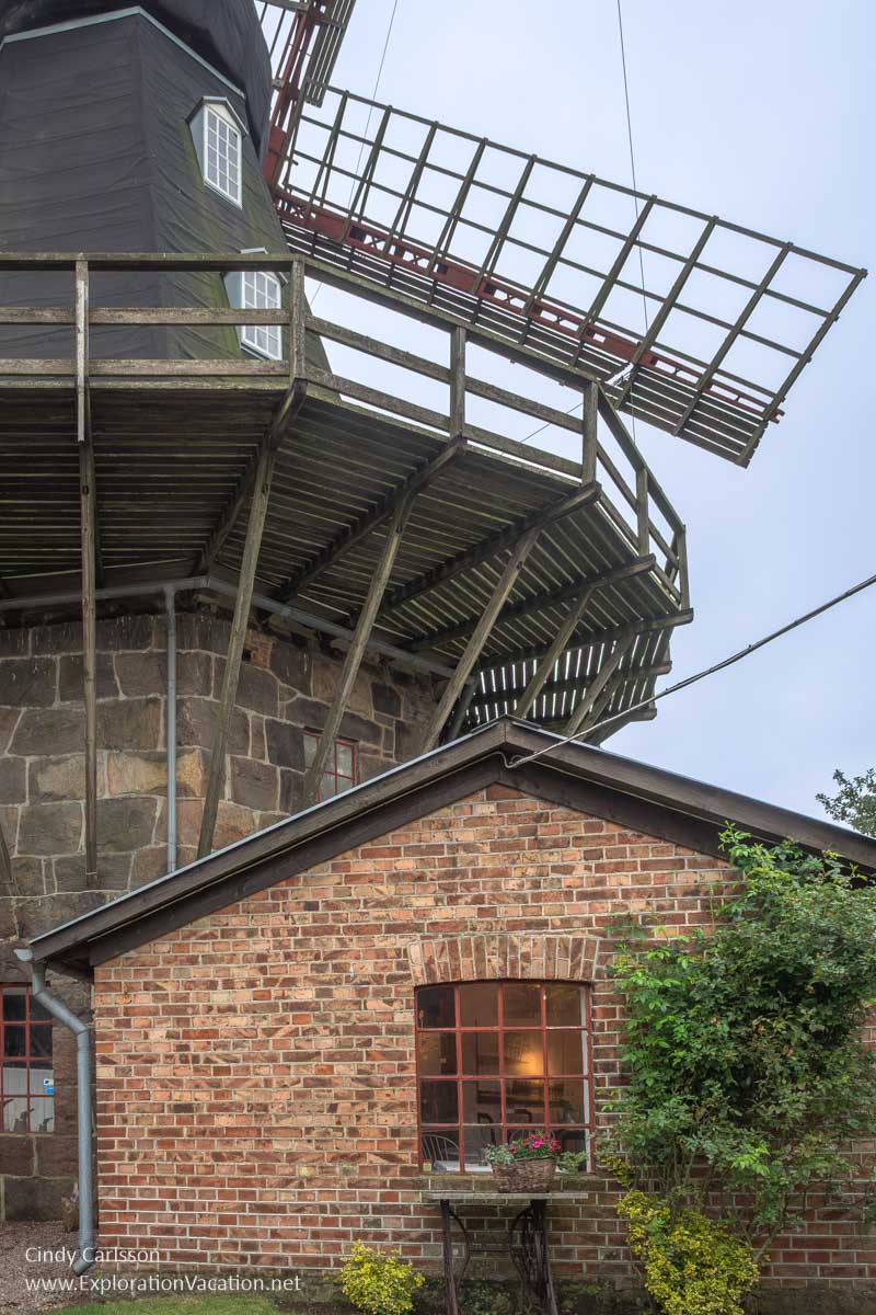 A small brick building attached to the base of a windmill.