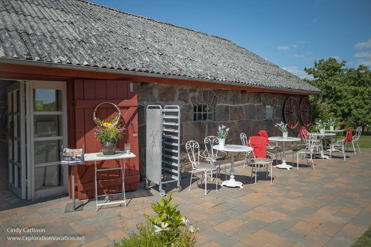 A low, long traditional building with cafe seating outside.