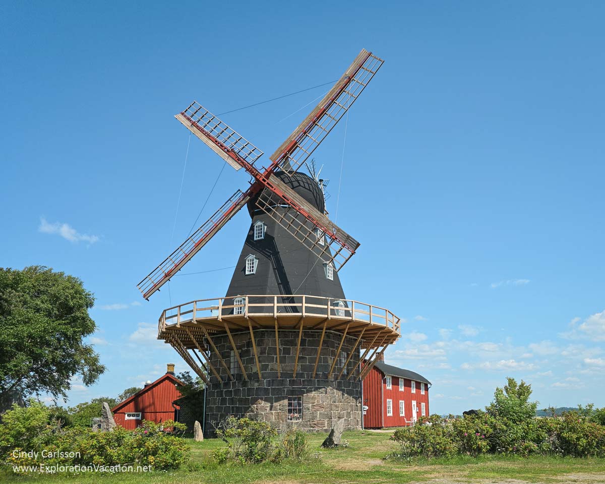 An old Dutch-style windmill for grinding grain and supporting buildings.