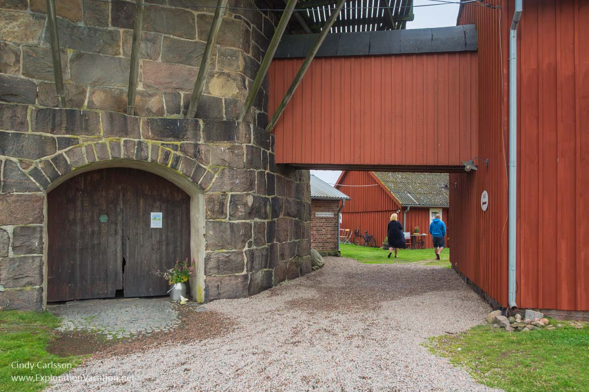 Entry to the windmill and courtyard with people walking into the courtyard.