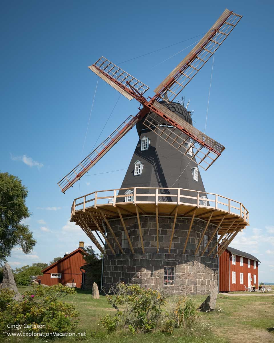 An old Dutch-style windmill for grinding grain and supporting buildings.
