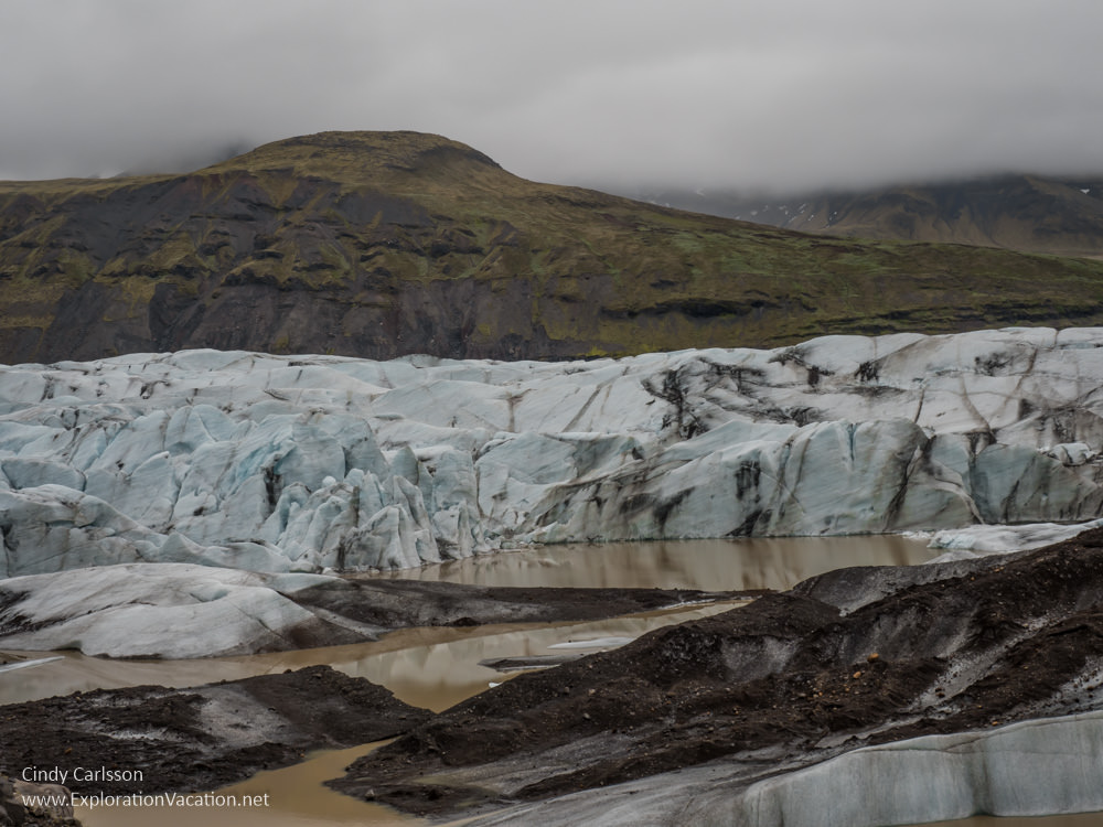 icebergs floating in a lagoon with mountains in the background
