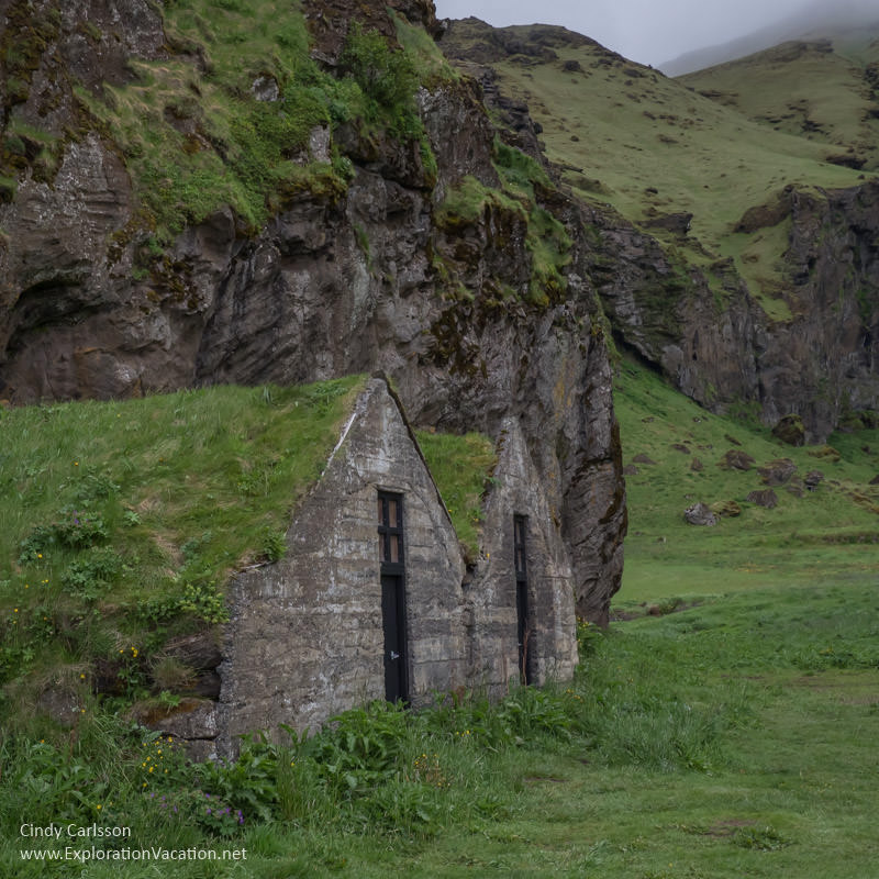 run-down turf houses below a mountain