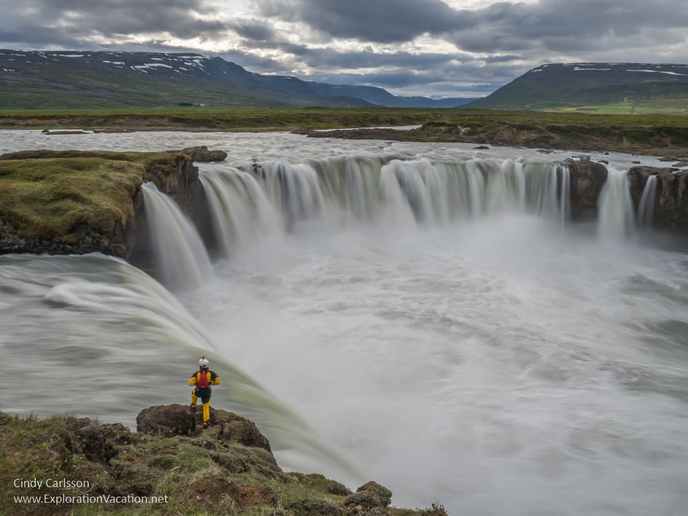 man standing at the edge of a massive waterfall
