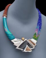 bead, stone, silver and other materials form a landscape as part of a necklace