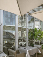 Restaurant patio with cathedral reflected in windows