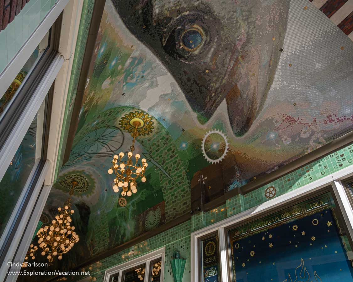 Photo of a passageway with glass mosaics of sea life and bicycle parts called the Grootste Amsterdamse Moza&iuml;ek 'Oersoep.' (Photo by Cindy Carlsson - ExplorationVacation.net)