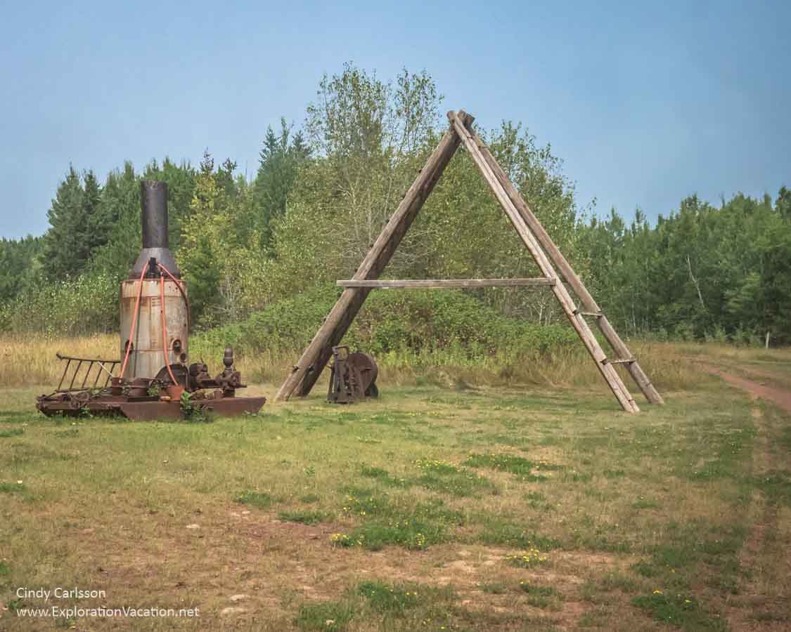 Wooden tripod and old rusty steam drill 