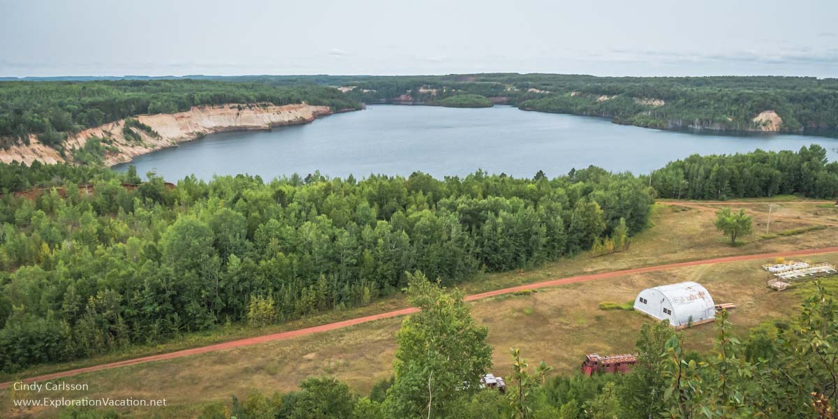 over view of lake in an ore pit with trees around it