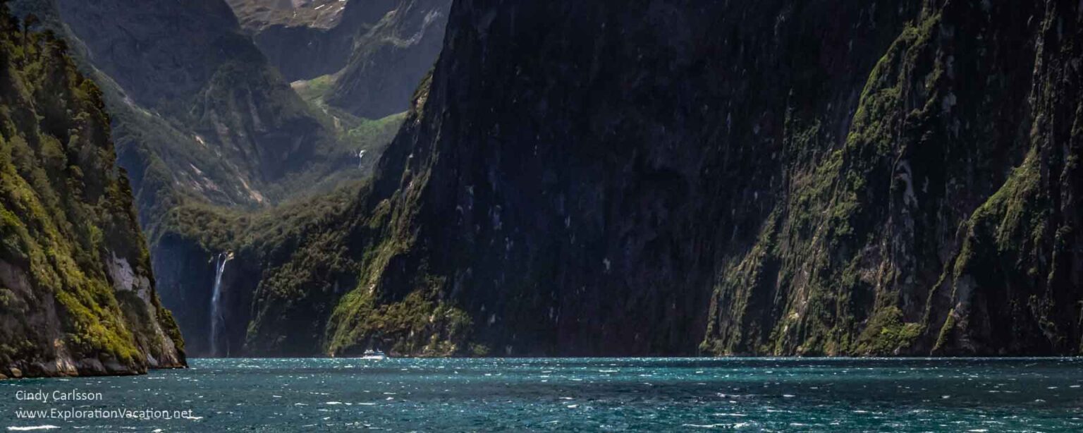 close-up of green mountains dropping into the sea and waterfall