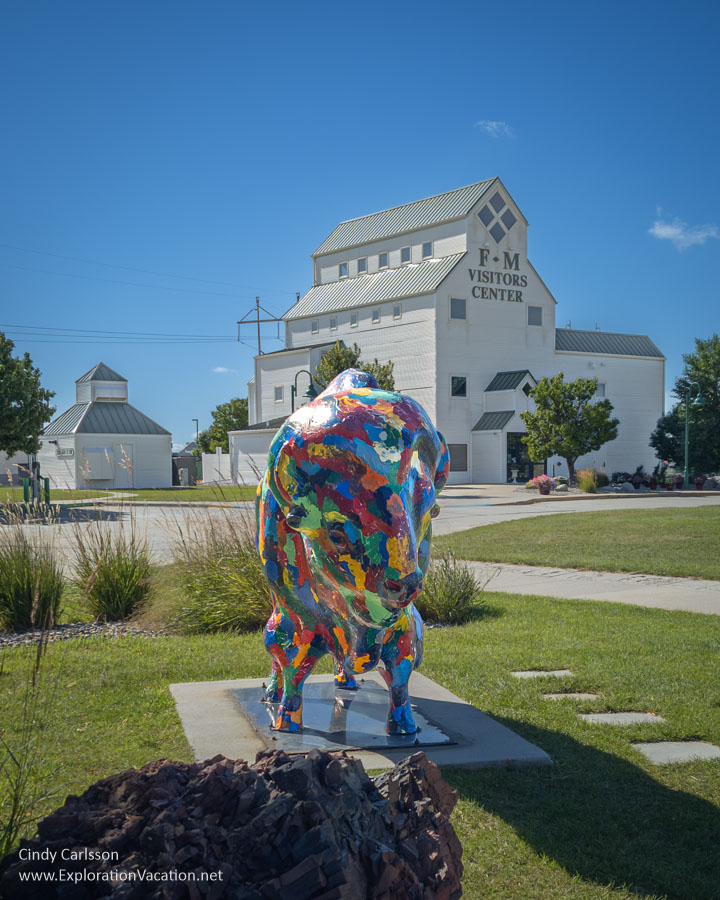 Photo of a colorful sculpture of a bison in front of a building that looks like an old grain elevator that houses the Fargo-Moorhead Visitor Center. (Photo &copy; Cindy Carlsson on ExplorationVacation.net)