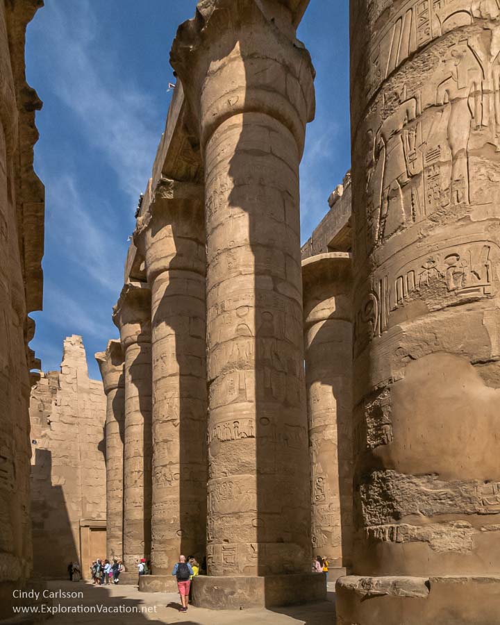 huge carved stone pillars reaching to the sky with tourists below