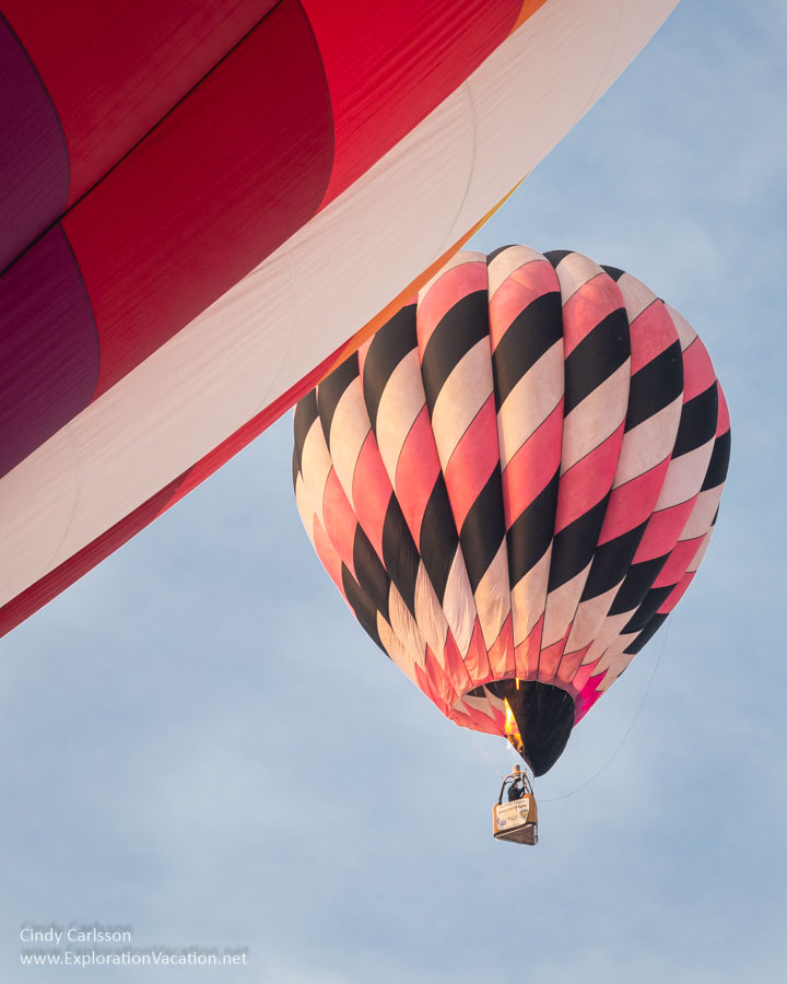 A balloon rises in the sky behind one still on the ground