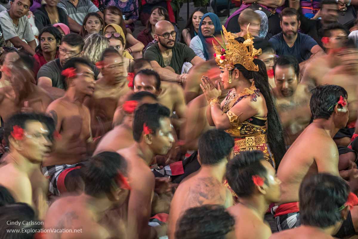 female dancer surrounded by men chanting