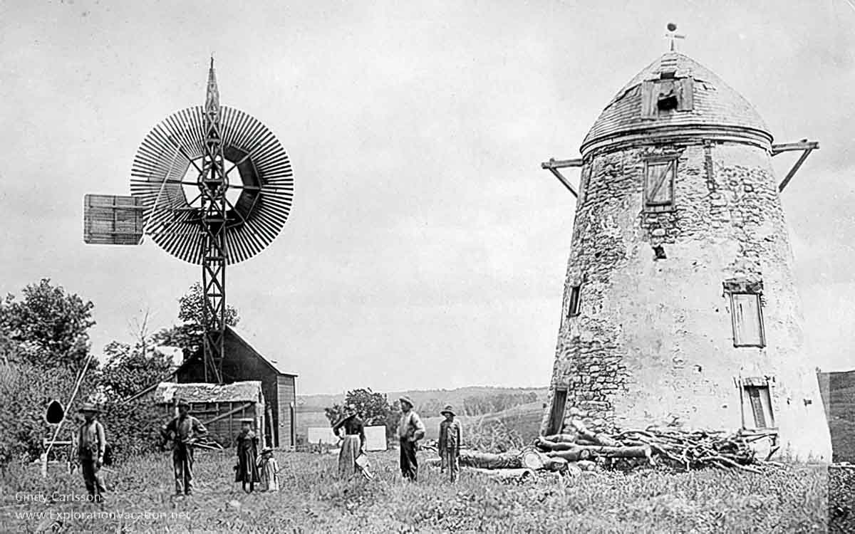 historic photo of a ruined windmill and other buildings with people