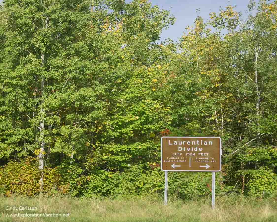 Sign with text "Laurentian Divide Elv 1524 Feet with arrows showing flowaging to the Gulf of Mexico and Hudson Bay
