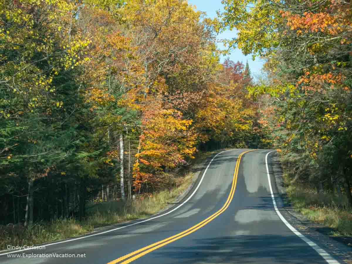 two-lane road through colorful fall forest 