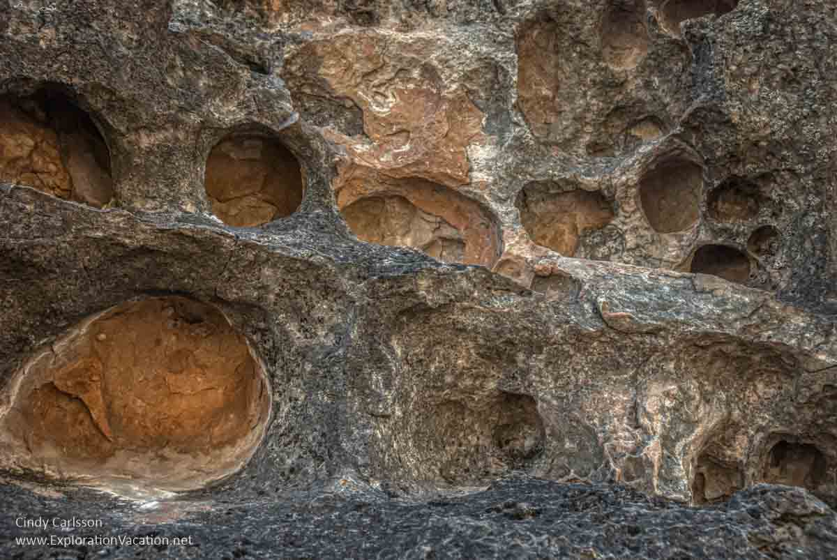 round eroded holes in a rock wall