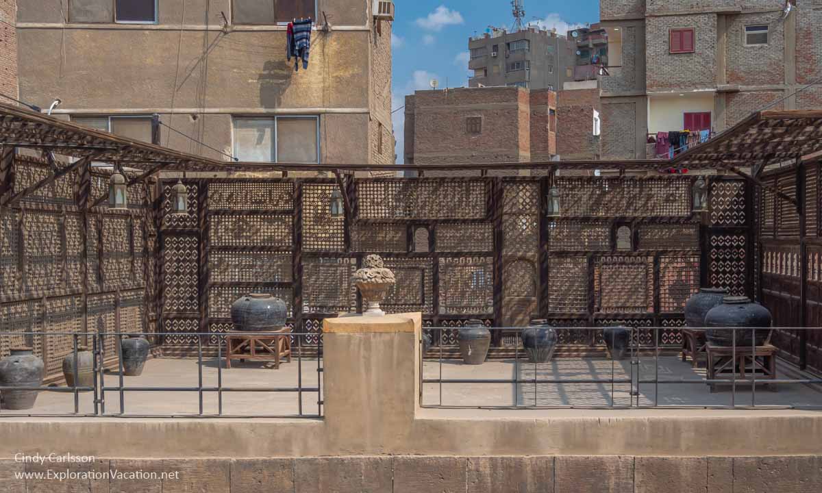 wood lattice and storage jars on a rooftop terrace in Cairo