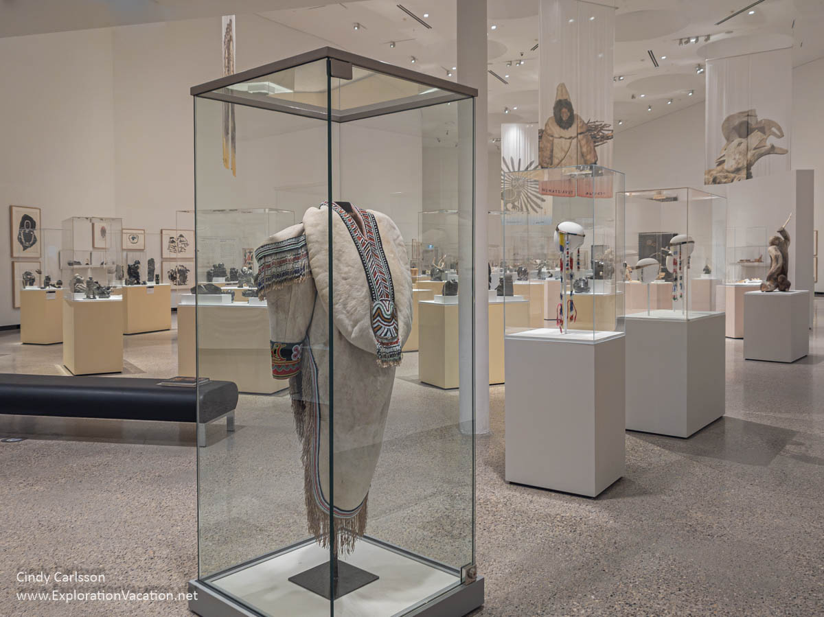 A portion of the Inuit Sanaugangit: Art Across Time exhibit with an amauti and other objects.