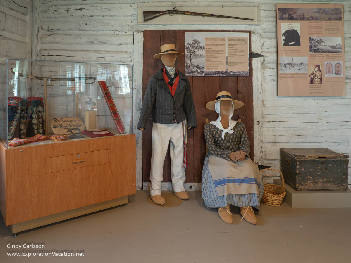 An exhibit inside the Saint Boniface Museum with two figures dressed as early settlers in the area.
