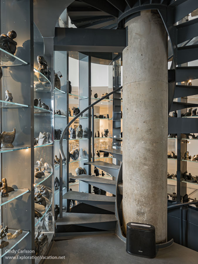 Inuit art and circular stairs inside a glass vault.