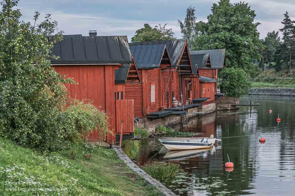 red Nordic buildings along a river in Finland