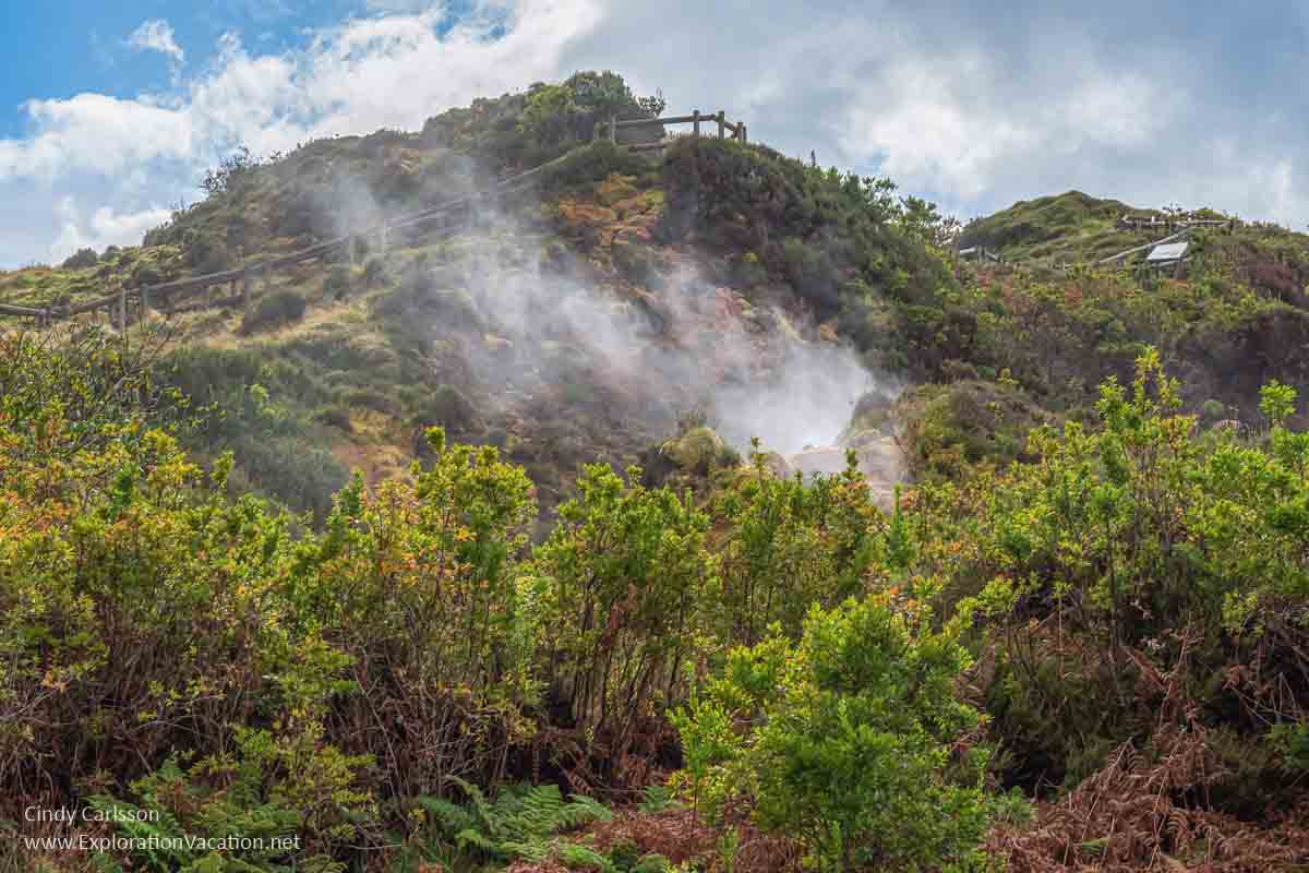 green hillside with steam rising from geothermal activity on Terceira Azores