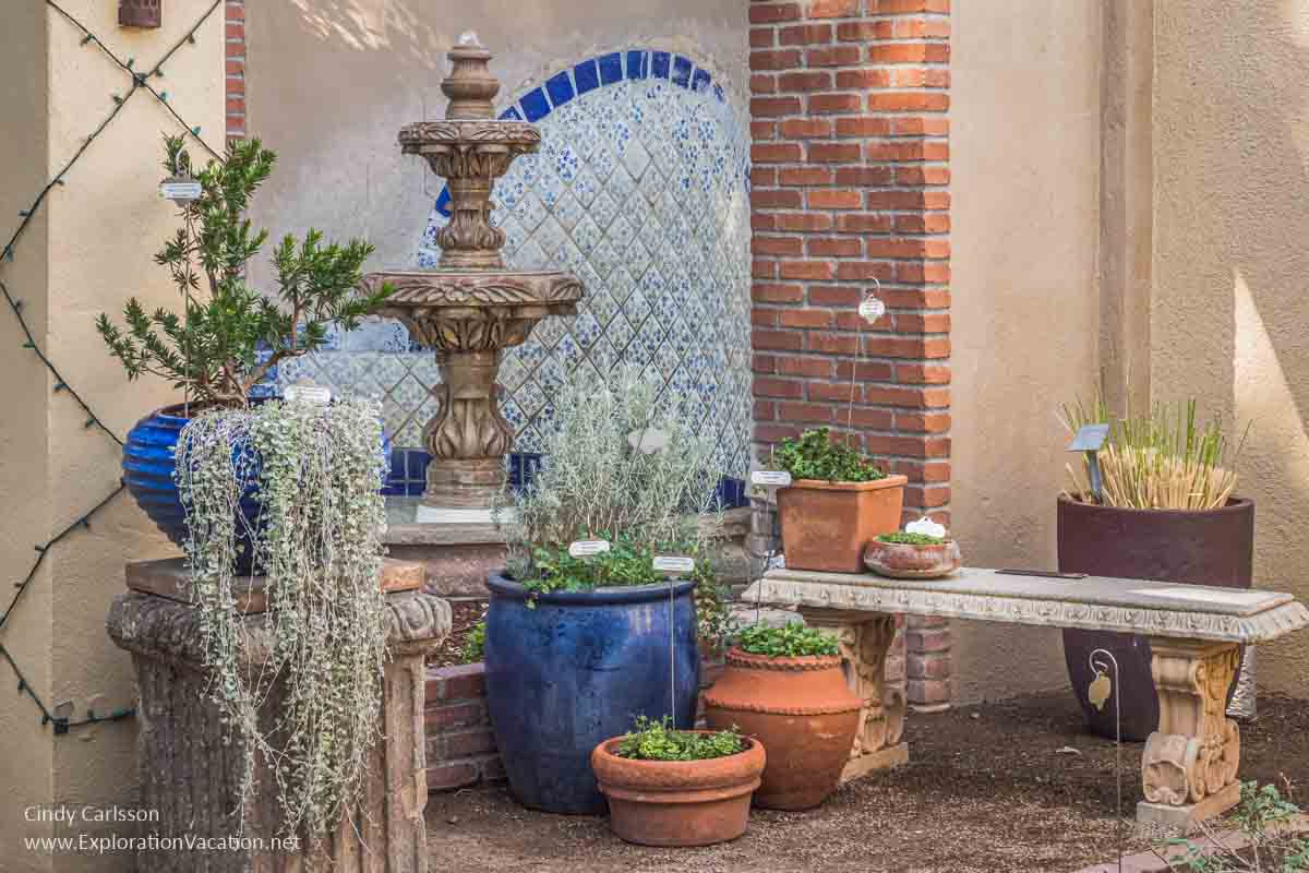 Photo of a fountain with pots of herbs