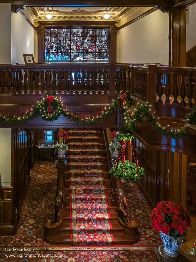 grand staircase leading to second level and a large window with a medieval war scene