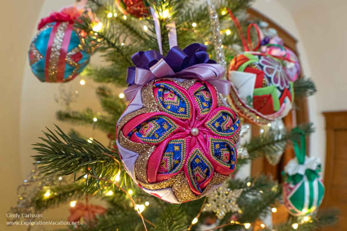 Photo of fabric Christmas ornaments made using traditional Hmong stitching techniques hanging on a Christmas tree at the American Swedish Institute (ASI) in Minneapolis, Minnesota, in 2021 &copy; Cindy Carlsson at ExplorationVacation.net