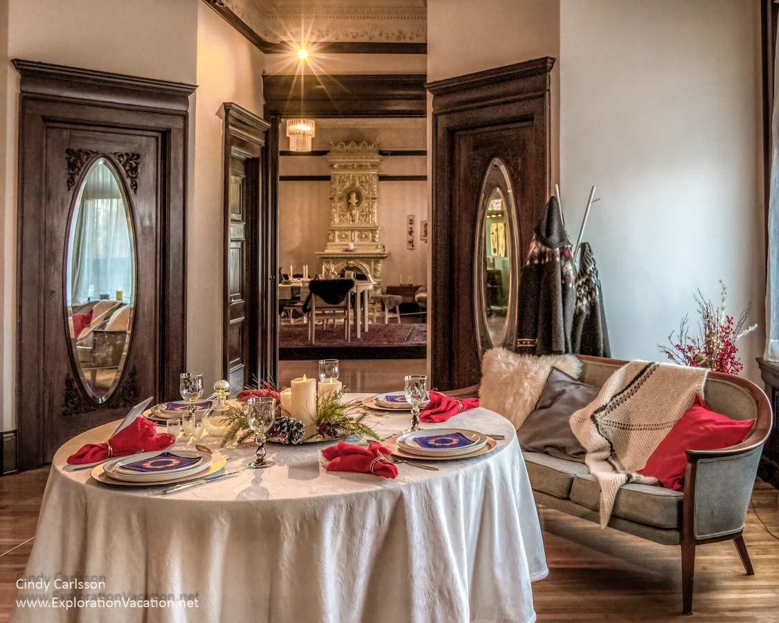 tables set for Christmas with view from one room into another