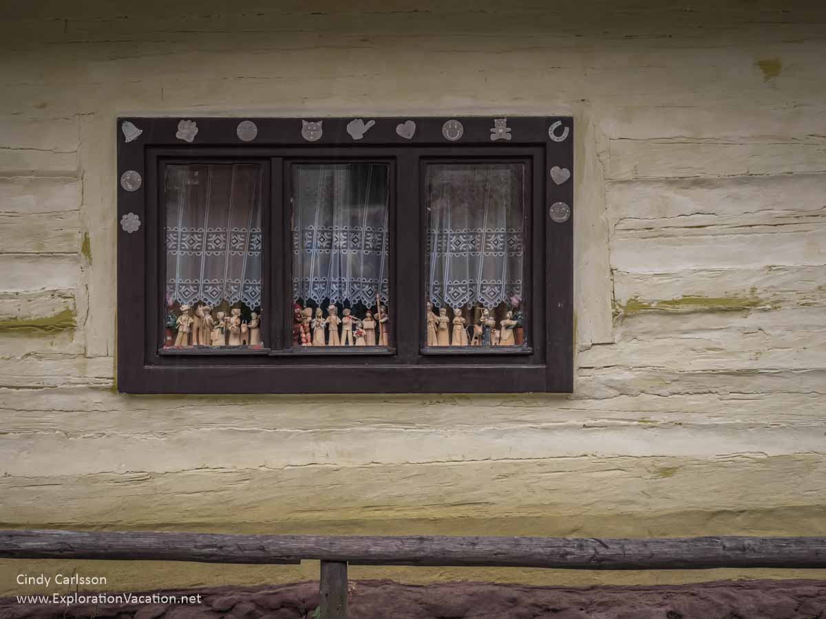 photo of window with folk carvings of people