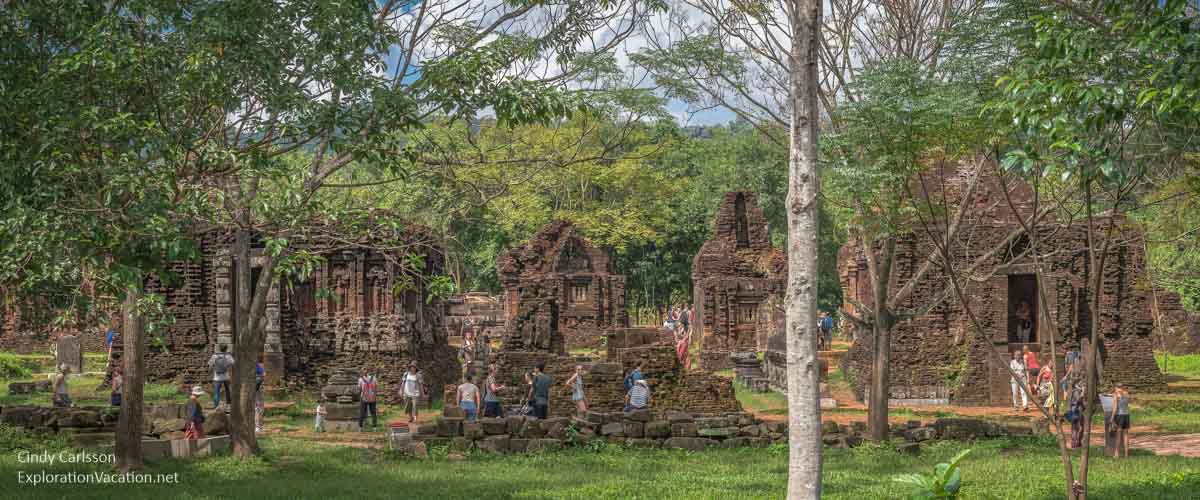 people looking at a row of ruined temples