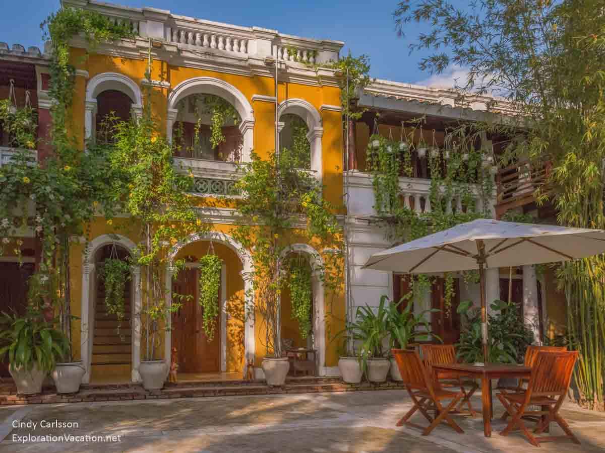 elegant two-story colonial-style hotel with patio seating in Vietnam